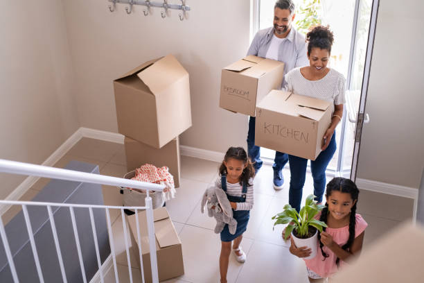 a family moving boxes into a house