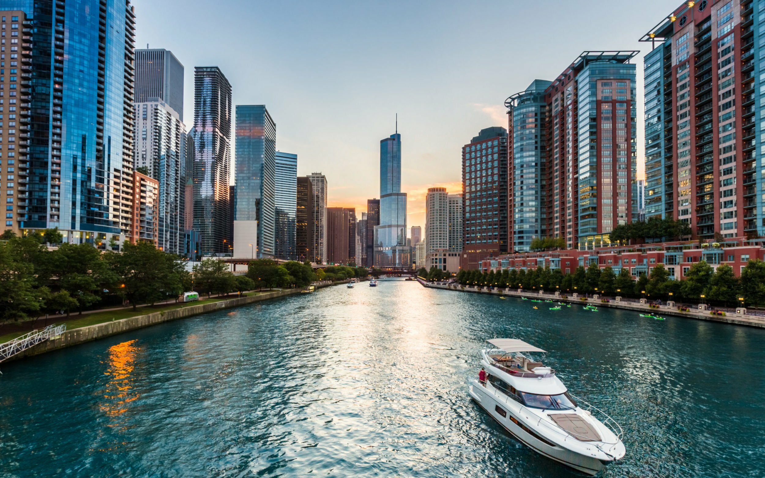 a river with boats on it and a city in the background