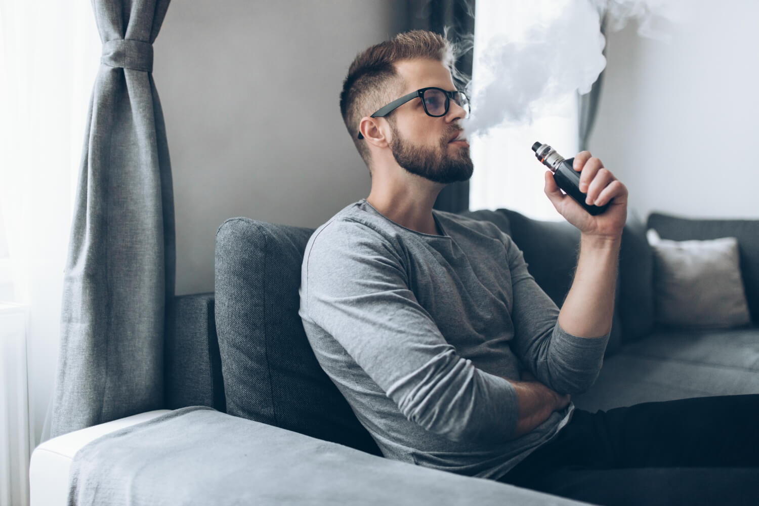 a man sitting on a couch holding a phone