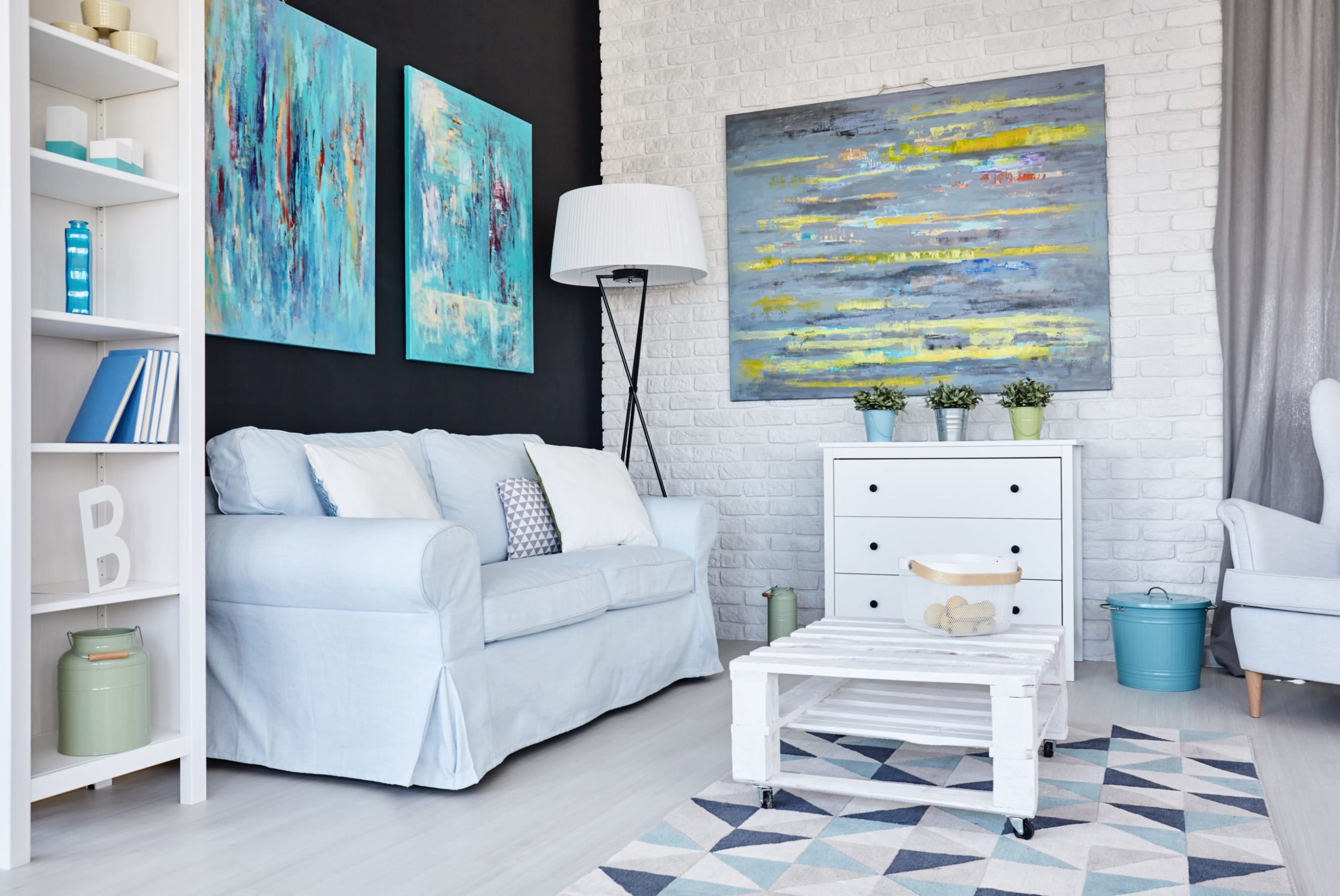 a room with a white couch and a white table and a blue and white rug