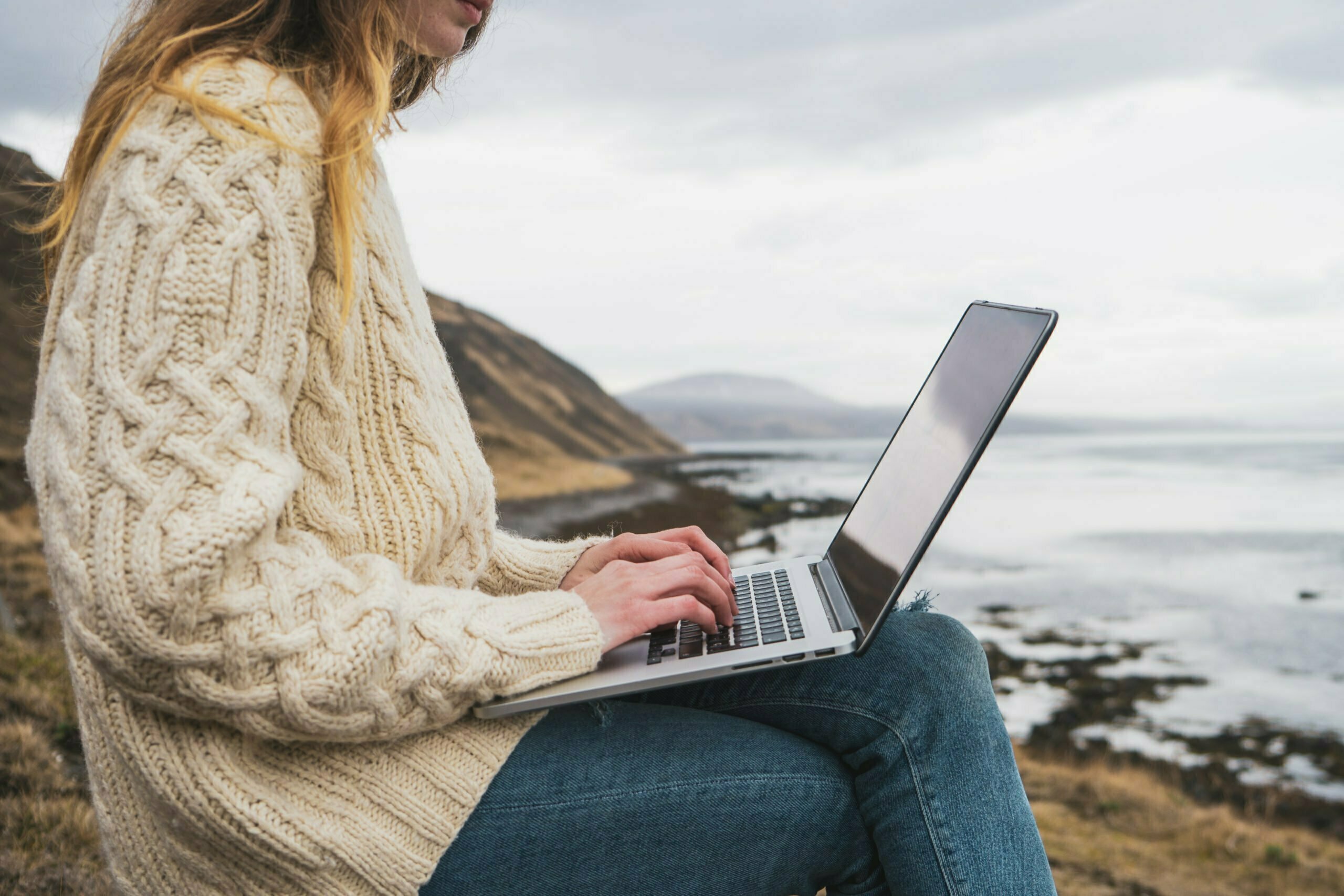 iceland woman using laptop at the coast       utc scaled