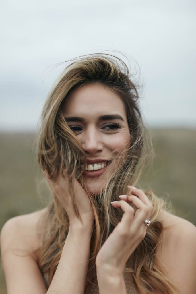 a woman smiling with her hand on her face